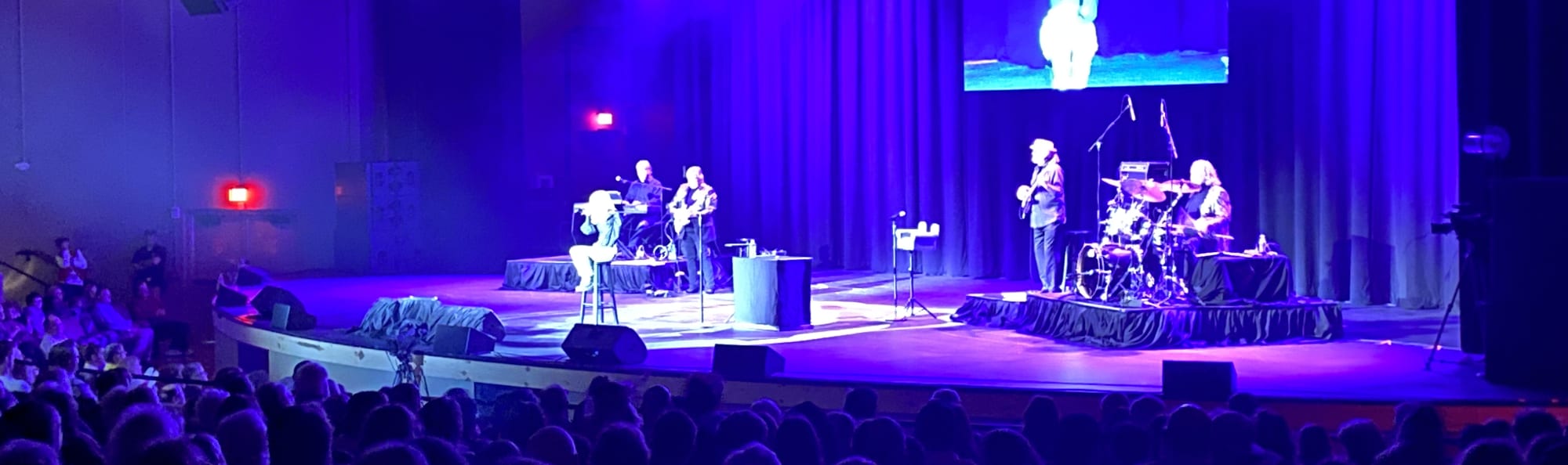 signer on stage in chair washed out by the lights Little Rock